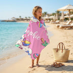 Child walking on beach wearing personalised microfibre towel with name, kids quick dry beach towel