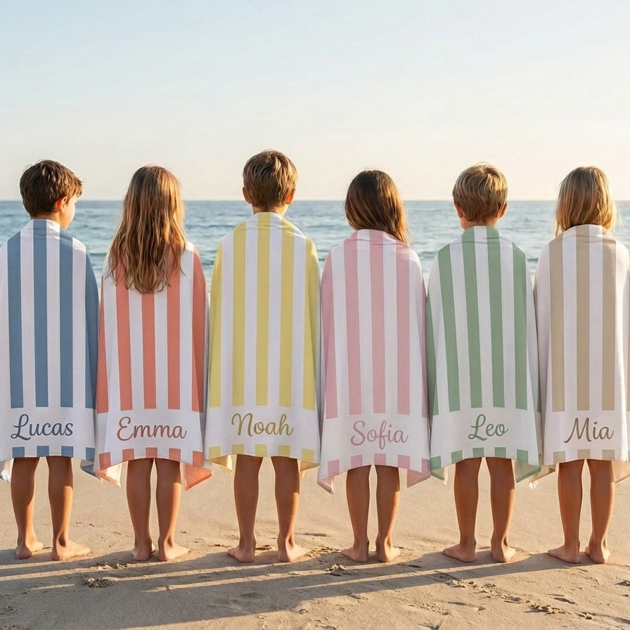 Group of personalised striped beach towels on beach, custom name microfibre towels