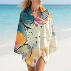 Microvezel strandhanddoek Coastal Bloom met abstracte bloemenprint op het strand