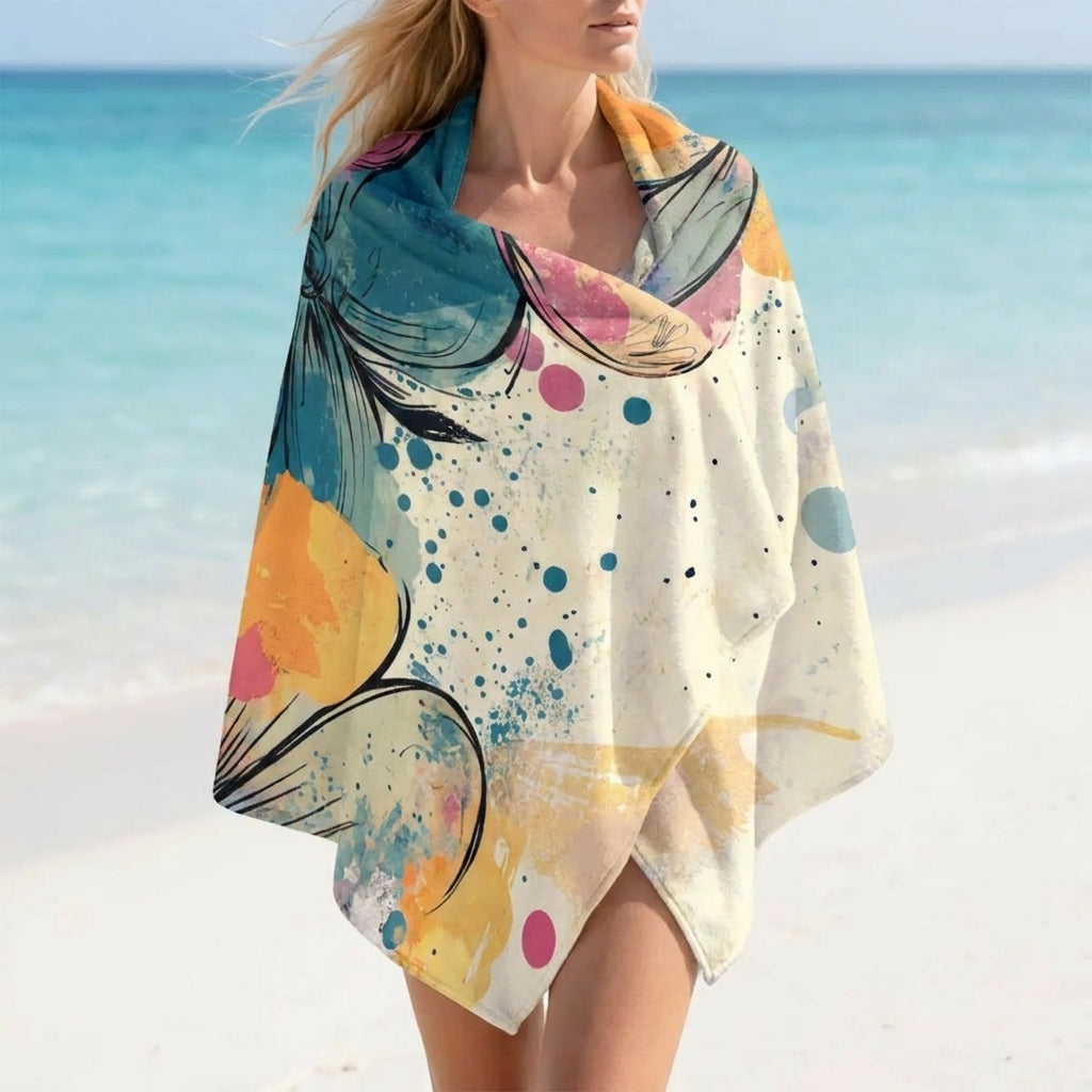 Microvezel strandhanddoek Coastal Bloom met abstracte bloemenprint op het strand