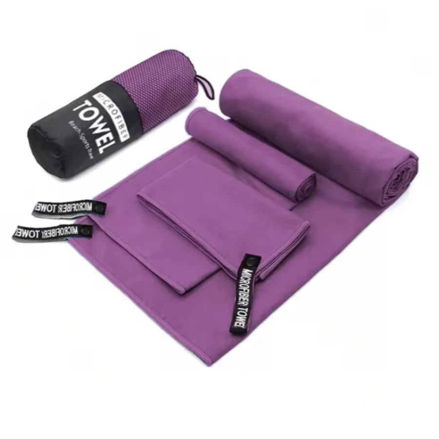 Complete 3-piece Purple microfibre towel set laid flat, showing all three sizes and the matching carry bag.