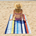 Riviera Stripe strandhanddoek op het zand voor strand en vakantie