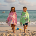 Children running on beach wearing personalised kids microfibre towels with names, quick dry kids beach towel